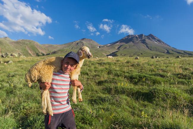 boy with sheep over his shoulders