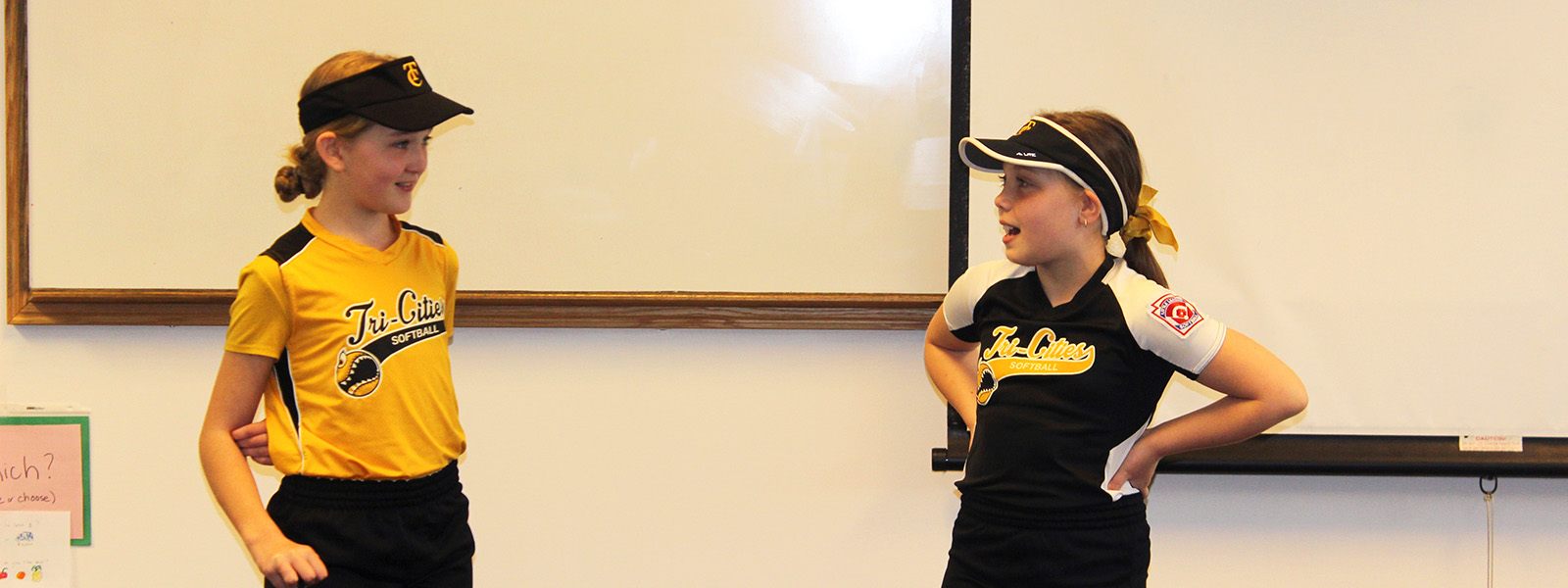 2 girls speaking in front of class