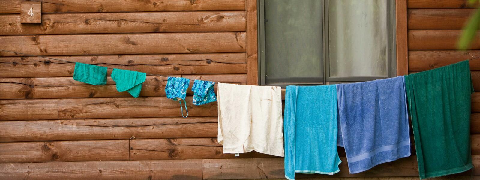 Towls and swimsuits hang on line in front of cabin