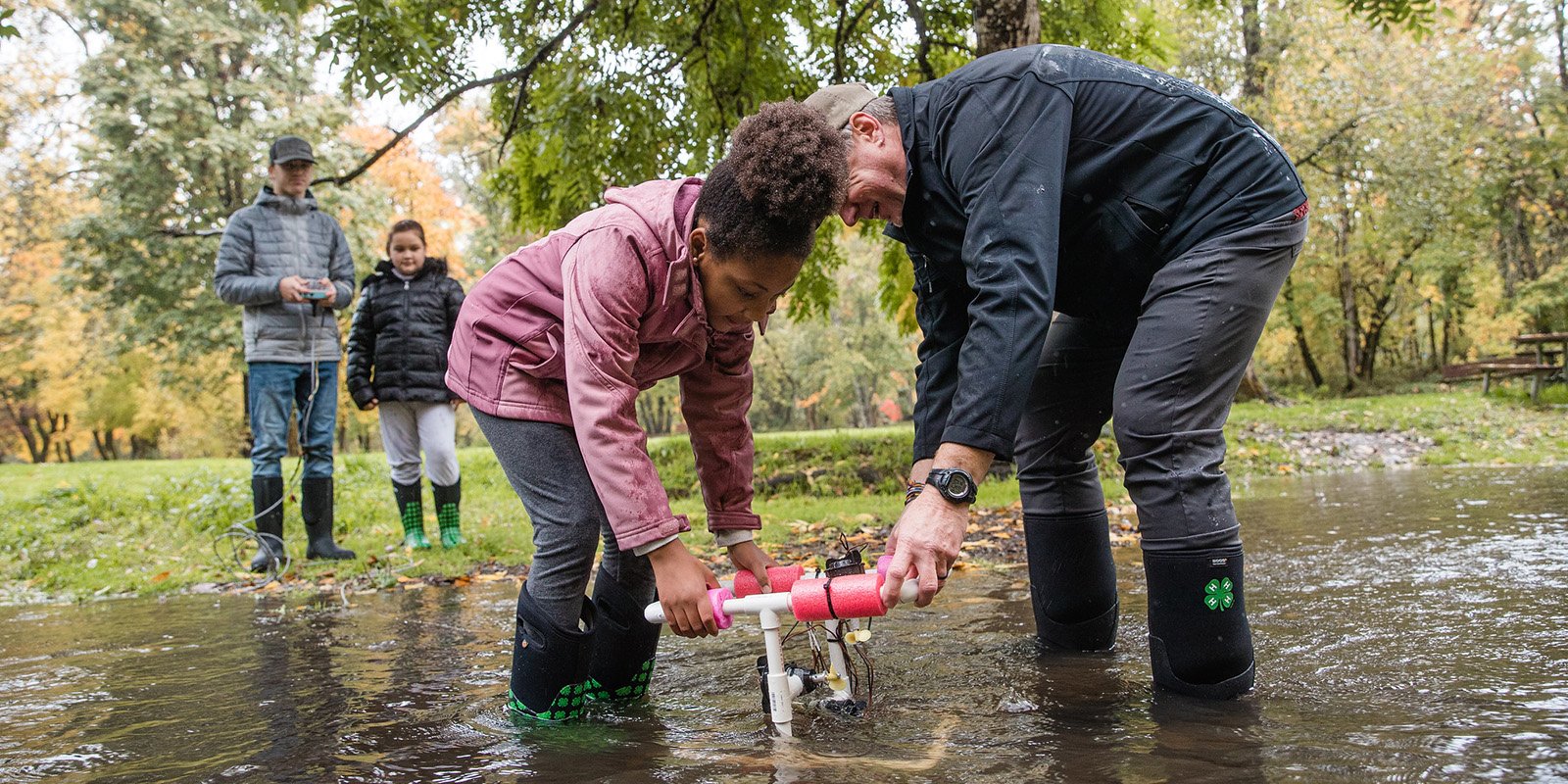 niña y hombre vadeando en el agua probando la calidad del agua