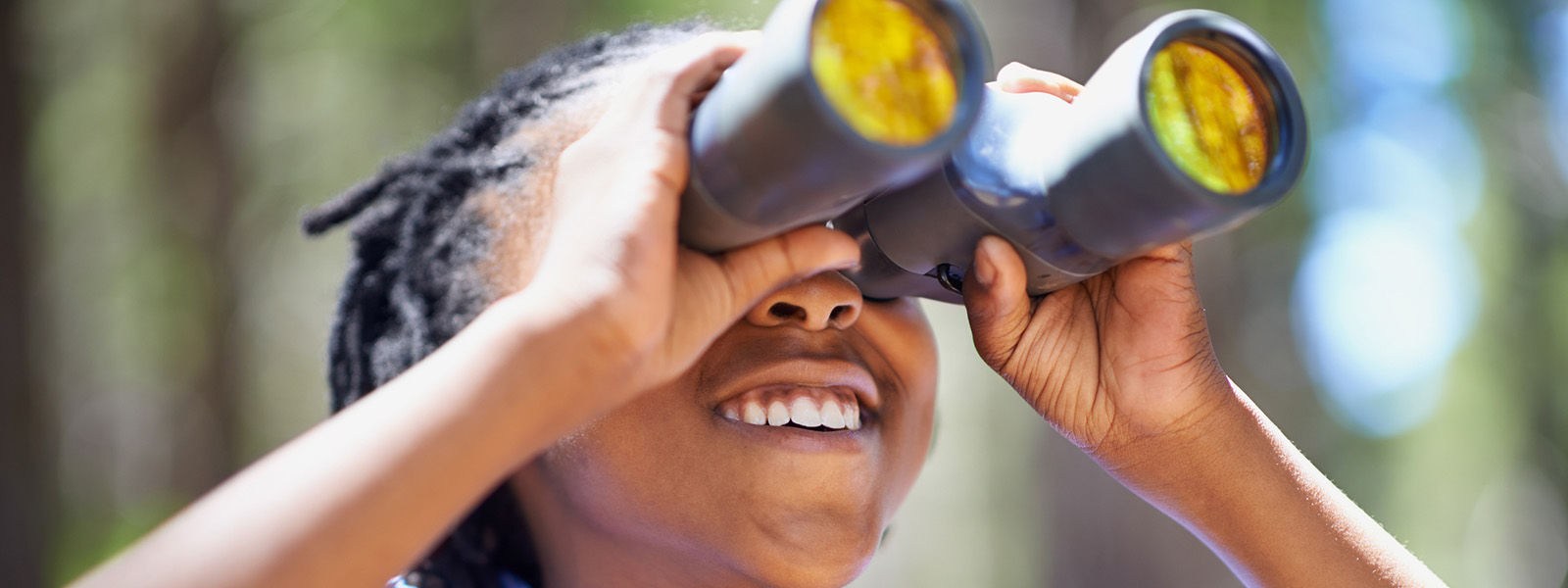 child looking through binoculars birdwatching