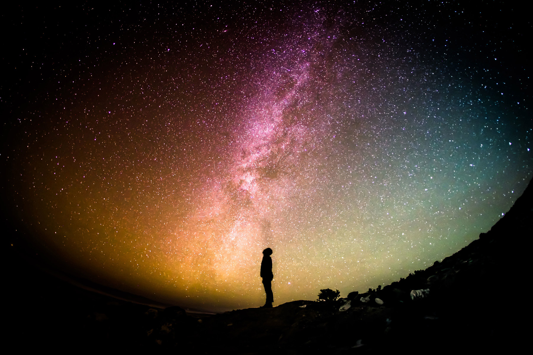 Night sky lit up and person silhouetted 
