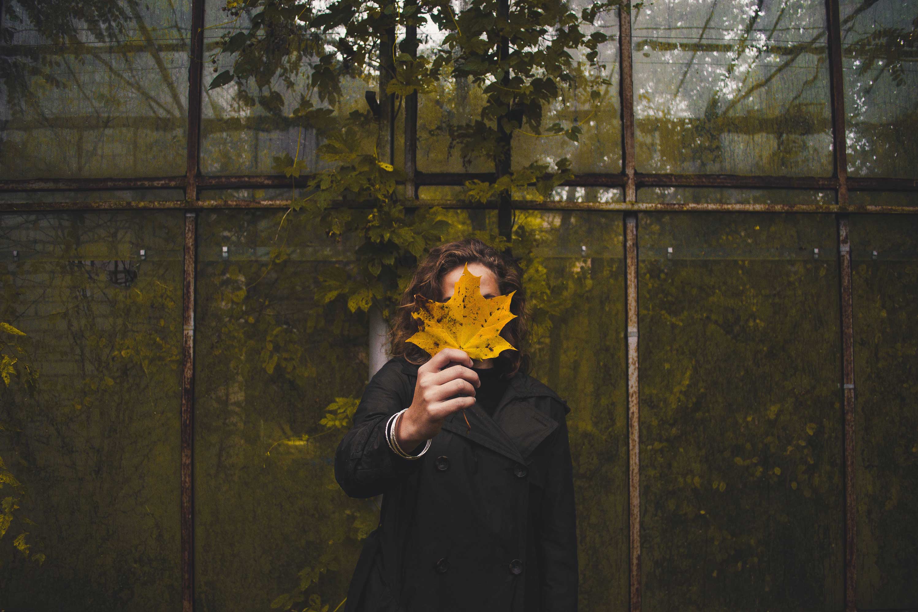 Girl holding large leaf in front of face