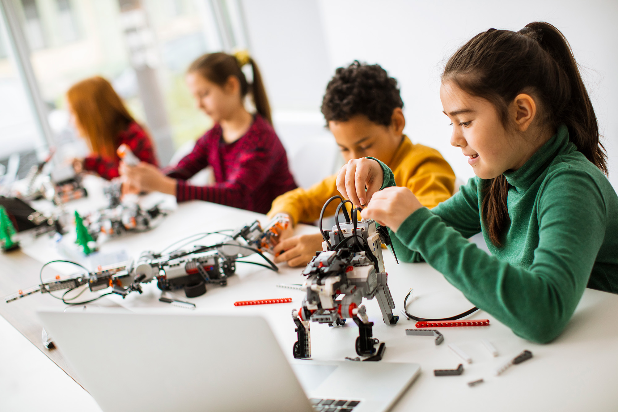 kids working on robotics with laptops