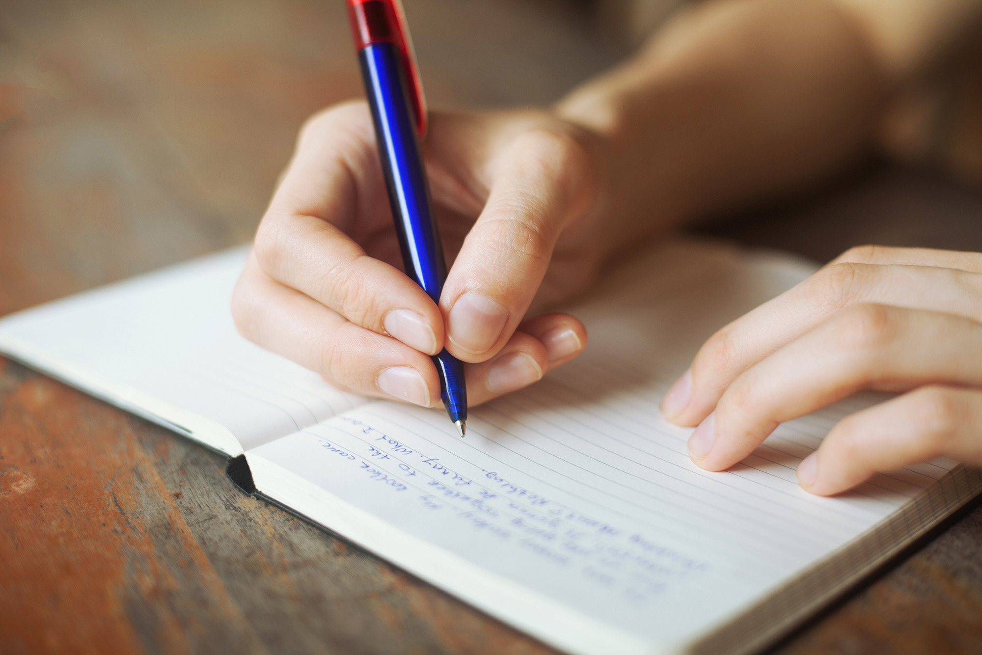 person writing in journal