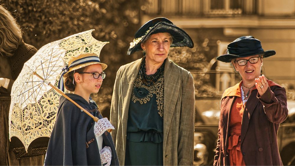 girl and two women in old timey costumes