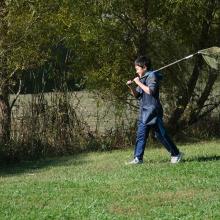 boy with net heading to river