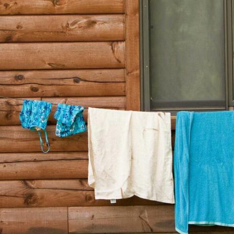 swimsuits hanging on clothesline in front of cabin