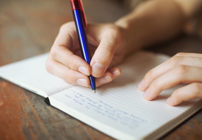 person writing in journal