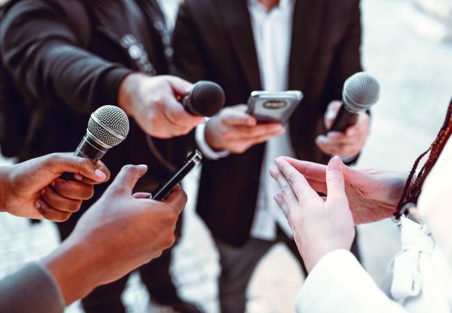 hands holding microphones and cell phones