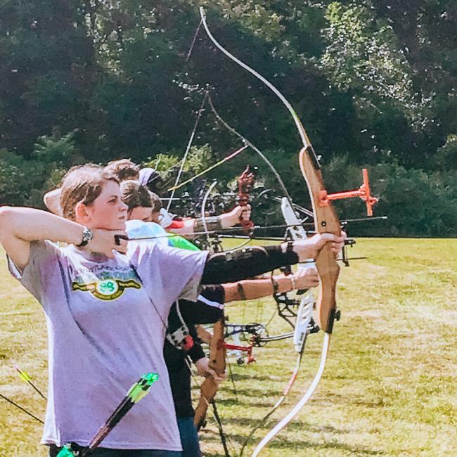 Group of teenagers shooting with bows