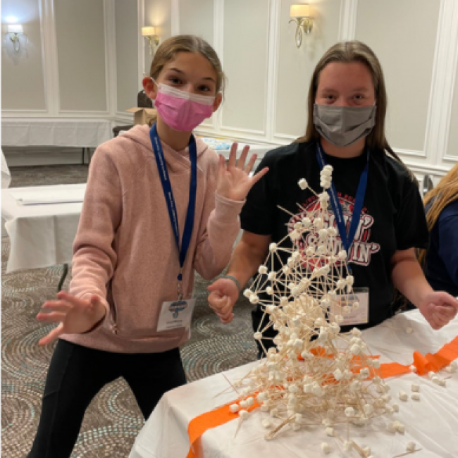 Girls build tower of toothpicks and marshmallows