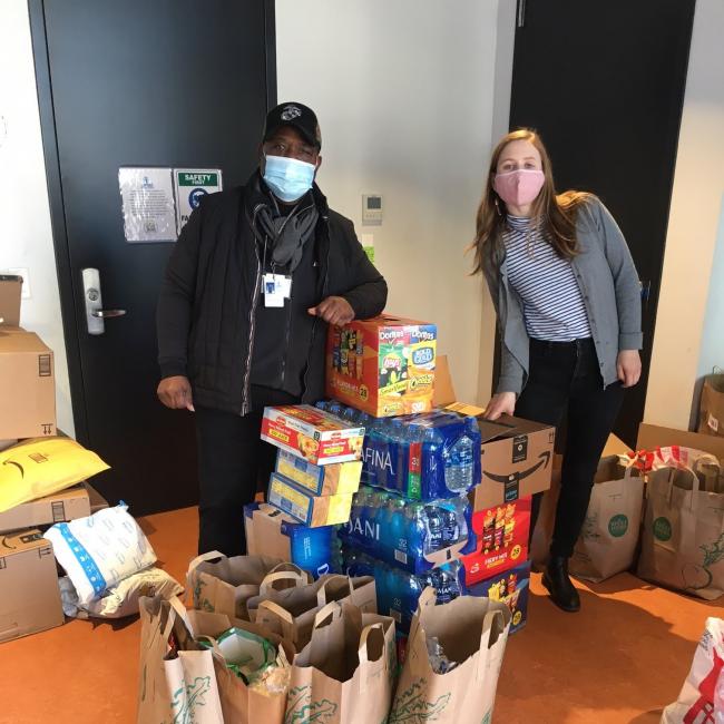 Man and 4-H member stand with cases of food