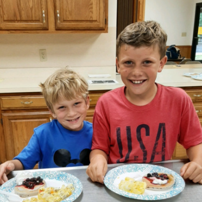 2 boys in kitchen with breakfast food they made