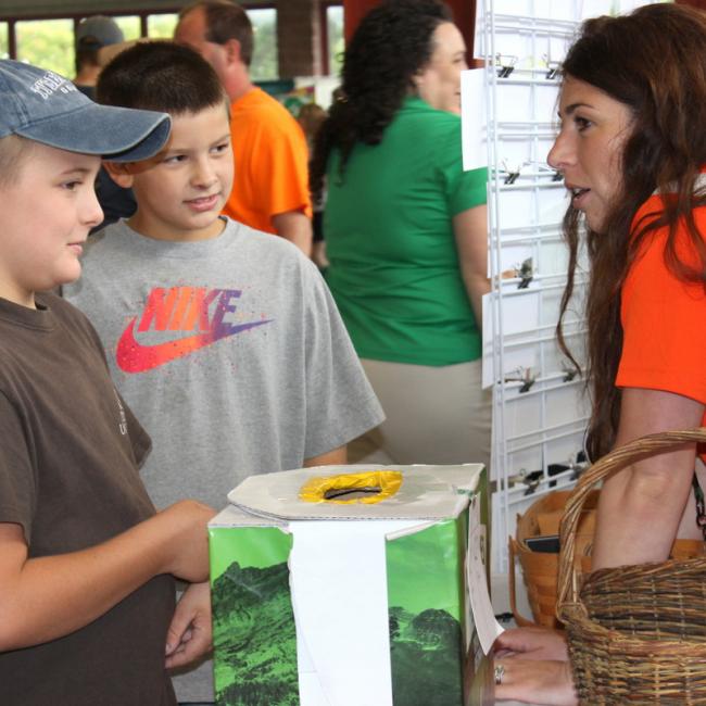 woman talking to boys at an alumni event