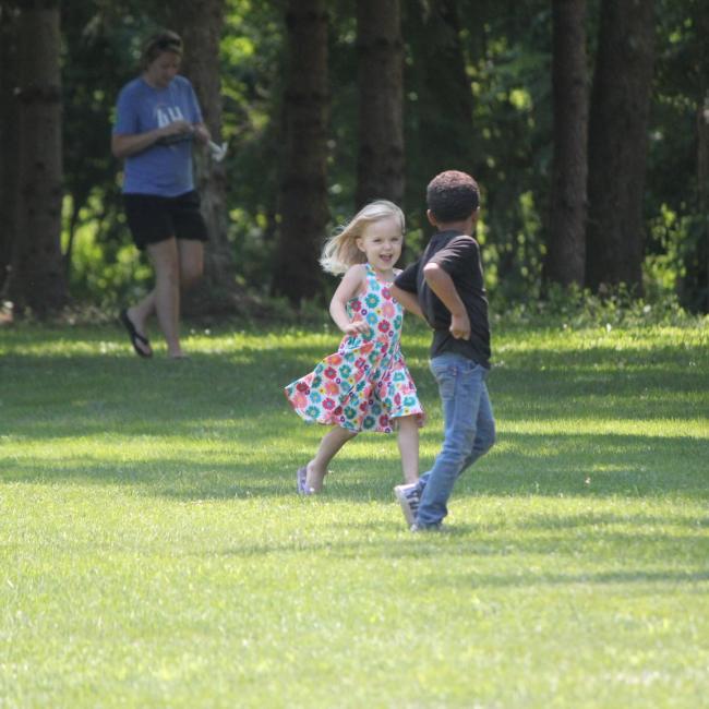 Kids running in field at camp