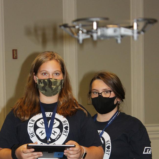 2 girls flying a drone