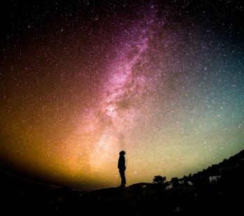 Night sky lit up and person silhouetted 