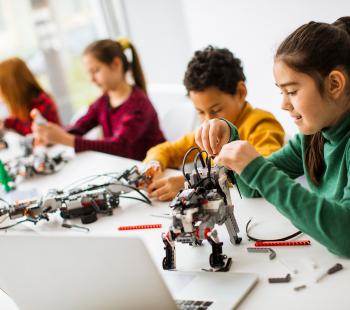 kids working on robotics with laptops