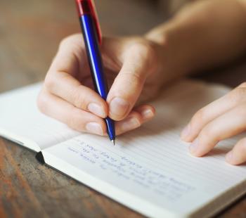person writing in journal