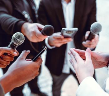 hands holding microphones and cell phones