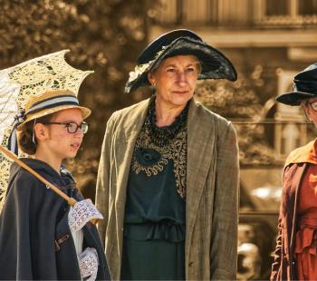 girl and two women in old timey costumes