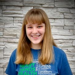 Girl with blonde hair and bangs in a blue shirt